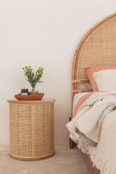 Koko Collective's Arched Natural Rattan Bedhead, displayed in a bedroom with the Ava bedside table, linen bedding and other natural styling details.